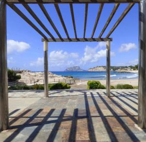 une pergola en bois avec vue sur la plage dans l'établissement Casita Mona - Attractive Studio Apartment 4kms from the beach, à Moraira
