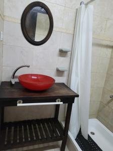 a bathroom with a red sink and a mirror at cabaña las casuarinas in San Clemente del Tuyú +7 photos