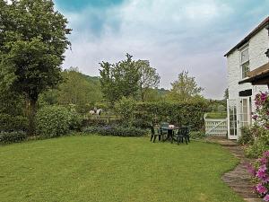 a yard with a table and chairs and a house at Ashberry Cottage in Rievaulx
