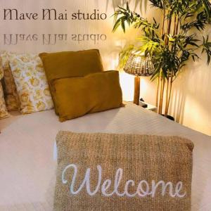 a bedroom with a bed with a welcome sign on it at Mave Mai Studio Papeete in Papeete