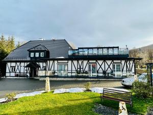 a large black and white house with a balcony at Apartamenty Pruskie in Karpacz