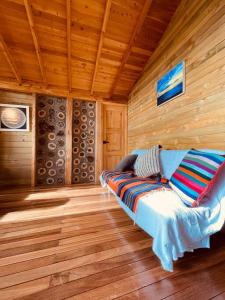 Habitación con sofá en una cabaña de madera en Beehouse Arví Cabaña, en Guarne