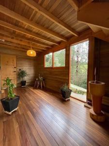 ein Wohnzimmer mit Topfpflanzen und Holzboden in der Unterkunft Beehouse Arví Cabaña in Guarne