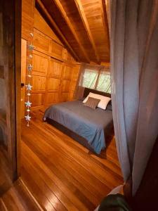 a small bedroom with a bed in a cabin at Beehouse Arví Cabaña in Guarne