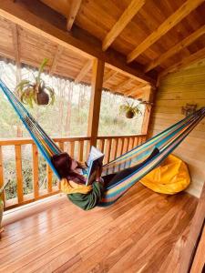 a person laying in a hammock with a laptop at Beehouse Arví Cabaña in Guarne