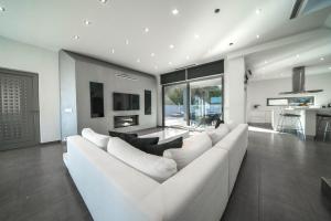 uma sala de estar com um sofá branco e uma lareira em La Maison Du Soleil em Varípetron