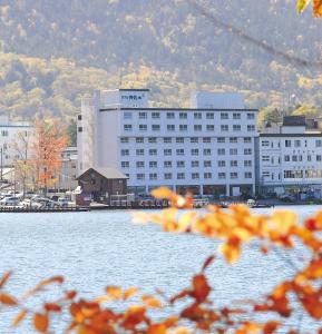 un gran edificio junto a una gran masa de agua en Hotel Gozensui, en Akankohan