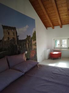 - une chambre avec un lit et une peinture murale dans l'établissement Una Rosa sul Mincio, à Valeggio sul Mincio