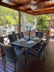 a table and chairs sitting on a deck at Mobile home Sea Jezera Village, otok Murter in Tisno