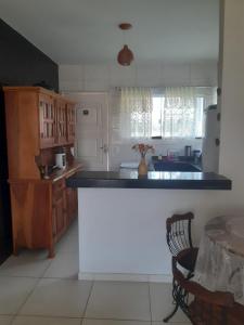 a kitchen with a black counter top and a table at Chalé das Conchas in Cabo Frio