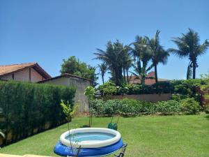 a pool in the yard of a house with palm trees at Chalé das Conchas in Cabo Frio