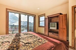 1 dormitorio con 1 cama, TV y ventana en Crested Butte Townhome with Views - Steps to Lifts!, en Mount Crested Butte