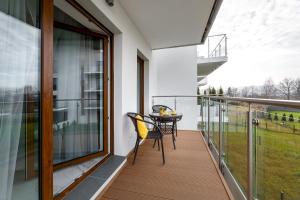 einen Balkon mit einem Tisch und Stühlen darauf in der Unterkunft Apartament SUNRISE Kudowa z balkonem in Kudowa-Zdrój