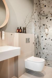 a white bathroom with a toilet and a sink at PO PTOKACH in Czarny Dunajec