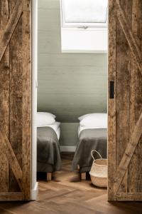 a bedroom with two beds and a sliding barn door at PO PTOKACH in Czarny Dunajec