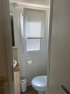 a small bathroom with a toilet and a window at Mobile home Sea Jezera Village, otok Murter in Tisno