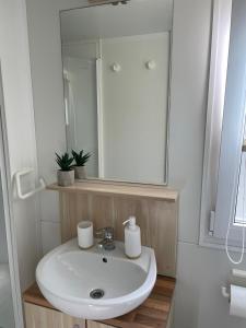 La salle de bains est pourvue d'un lavabo blanc et d'un miroir. dans l'établissement Mobile home Sea Jezera Village, otok Murter, à Tisno