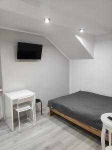 a bedroom with a bed and a desk and a tv at Noclegi u Sylwii przy Termach w Cieplicach in Jelenia Góra