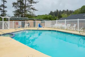 Long Beach Camping Resort Studio Cabin 3 في Seaview: مسبح وكراسي وسياج ابيض