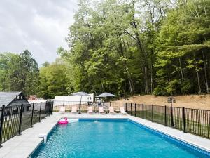 una piscina con una valla negra y un juguete rosa. en Hideaway Lodge - Glen Lake, Lake George en Lake George