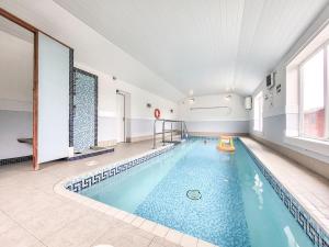 a large swimming pool in a building with a large window at Brompton Lodge in Ganton