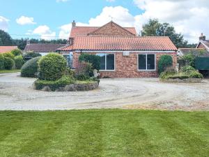 a house with a gravel driveway in front of it at Brompton Lodge in Ganton