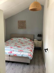 a bedroom with a bed with pink flamingos on it at Linderhuisje, rust, ruimte, privacy en natuur in Linde