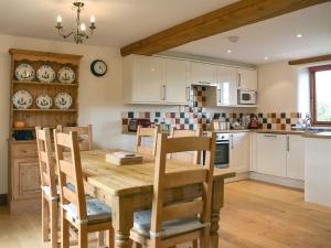 a kitchen with a wooden table and wooden chairs at Cowleaze - Dbbl in Leigh