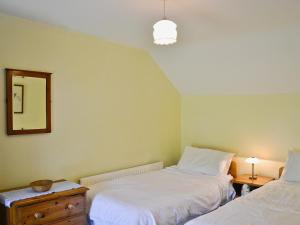 1 dormitorio con 2 camas y espejo en Murton Farm Cottage en Bishopston