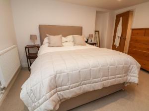 a bedroom with a large white bed and a dresser at Castle House in Rhyl
