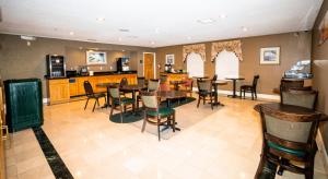 jadalnia ze stołami i krzesłami oraz kuchnia w obiekcie Econo Lodge w mieście Raleigh
