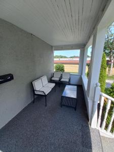 um alpendre com duas cadeiras e uma mesa em Niagara Falls Dream Family Retreat em Cataratas do Niágara