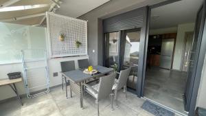 a dining room with a table and chairs at Thalassa Apartment in Nea Peramos +7 photos