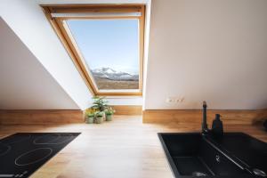 a kitchen with a sink and a window at Cozy mountain attic apartment in High Tatras in Veľká Lomnica