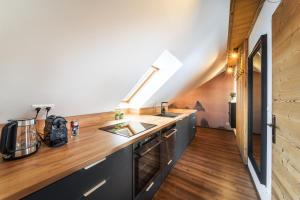 a kitchen with a sink and a counter top at Cozy mountain attic apartment in High Tatras in Veľká Lomnica