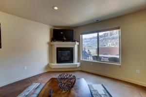 a living room with a fireplace and a large window at Prickly Pear Vista in Moab