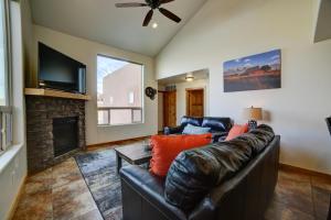 a living room with a leather couch and a fireplace at Steel Bender Villa in Moab