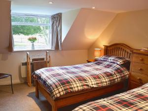 um quarto com 2 camas e uma janela em Longcroft Cottage - 28233 em Old Rayne