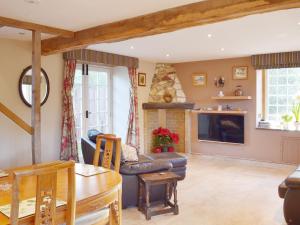 a living room with a couch and a fireplace at Brixton Barn in Mottistone