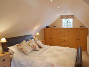 a bedroom with a bed with pillows on it at Brixton Barn in Mottistone
