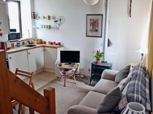 a living room with a couch and a table at Honeysuckle Cottage in Nerquis