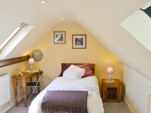 a bedroom with a bed and two night stands at The Coach House in Yaxham