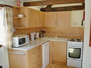 a small kitchen with a microwave and a stove at Pinewood - E3077 in Thorpe Market