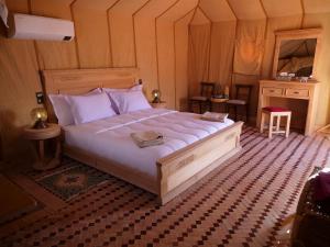 ein Schlafzimmer mit einem großen Bett in einem Zimmer in der Unterkunft Royal Luxury Camp in Merzouga