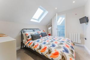 a bedroom with a bed with a colorful comforter at Fishermans Rest in Sheringham