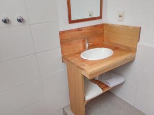 a bathroom with a wooden vanity with a sink at JACHA INTI in Isla de Sol