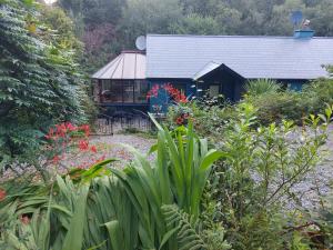 a house with a garden in front of it at Harbourside House Glengarriff in Glengarriff