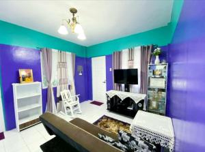 a living room with purple and green walls at Kalai's Rental Dwellings (KRD) in Cotcot