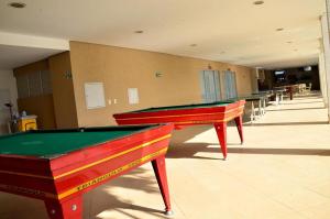 dos mesas de ping pong seguidas en una habitación en Apto c piscina aquecida e Wi-Fi em Caldas Novas GO, en Caldas Novas