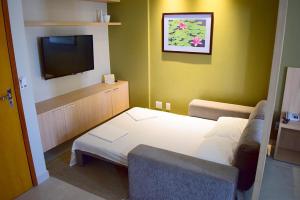 Habitación pequeña con cama y TV. en Apto c piscina aquecida e Wi-Fi em Caldas Novas GO, en Caldas Novas